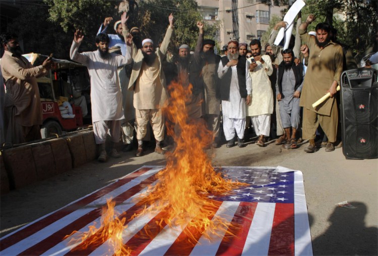 Pakistanis burn a representation of the U.S. flag during a protest rally in Hyderabad, Pakistan, Thursday. Hundreds of Islamists have rallied in major cities of Pakistan, condemning President Trump for declaring Jerusalem as Israel's capital.