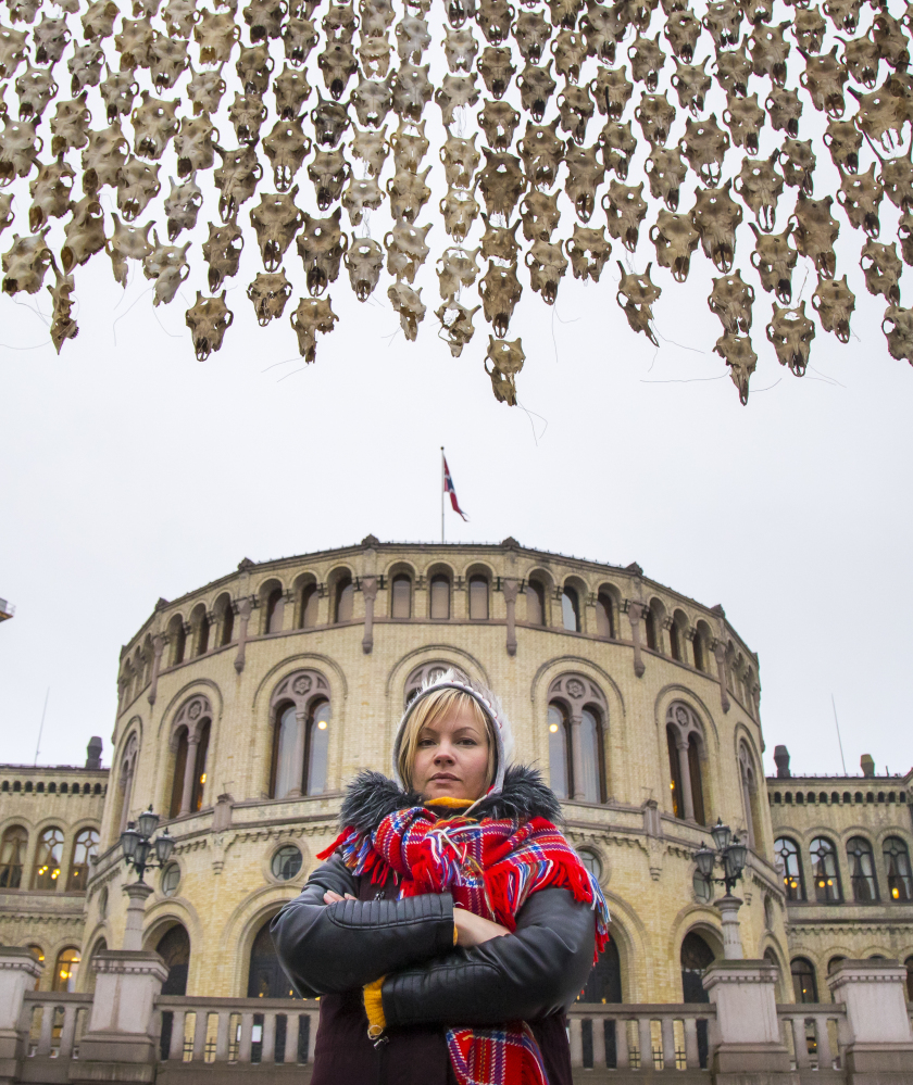 To protest culling reindeer herds, Maret Anne Sara poses by her artwork of 400 bullet-ridden reindeer skulls near Parliament in Oslo, Norway, Wednesday.