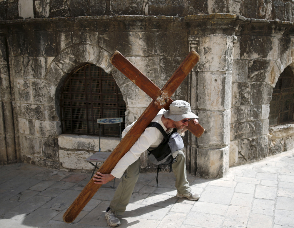 A Christian worshipper, left, poses last year for a picture on Good Friday near the Church of the Holy Sepulchre in Jerusalem. Above, a Jewish worshipper prays at the Western Wall, Judaism's most holy site for prayer.