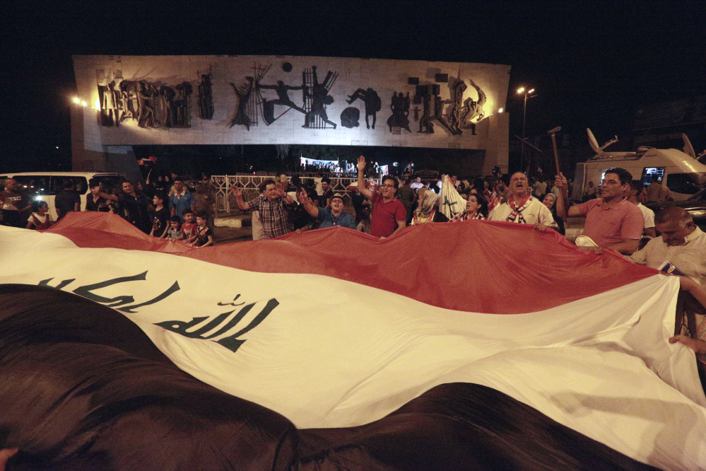 Iraqis celebrate while holding a giant national flag after Iraqi Prime Minister Haider al-Abadi declared victory against the Islamic State group in Mosul, Iraq, in July. Iraq said Saturday that its war against ISIS is over after more than three years of combat operations drove the extremists from all of the territory they once held.