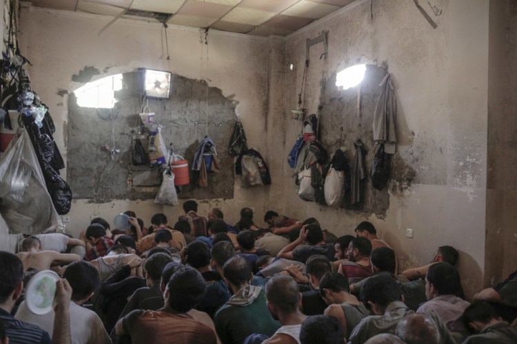 Suspected Islamic State members sit inside a small room in a prison south of Mosul, Iraq, in July. Prime Minister Haider al-Abadi announced Saturday that Iraqi forces were in full control of the country.