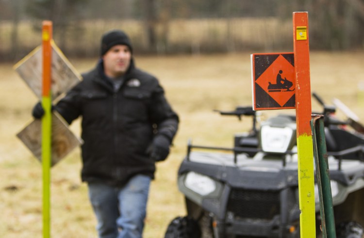 Jeb Pruett, a member of the Windham Drifters Snowmobile Club, helps mark trails early Saturday in preparation for the season. The club looks after about 45 miles of trails. All told, snowmobilers contribute $350 million annually to the state's economy.