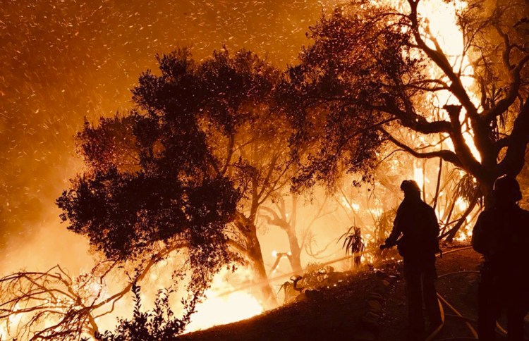 Santa Barbara County Fire Department personnel knock down flames as they advance on homes atop Shepherd Mesa Road in Carpinteria, Calif. A flare-up on the western edge of Southern California's largest wildfire sent residents fleeing.