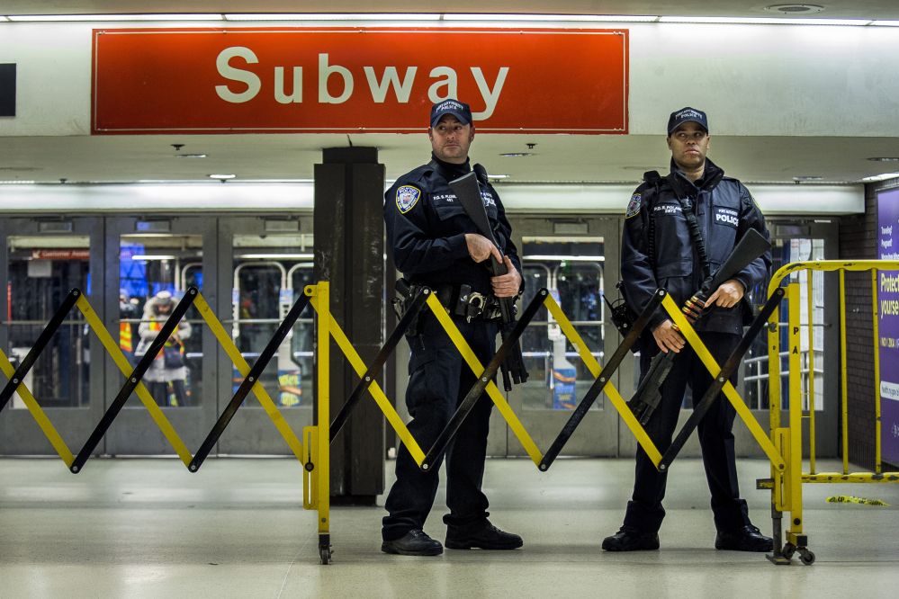 Police stand guard inside the Port Authority Bus Terminal following an explosion near Times Square on Monday in New York. Police said a man with a pipe bomb strapped to his body set off the crude device in a passageway under 42nd Street between Seventh and Eighth avenues.