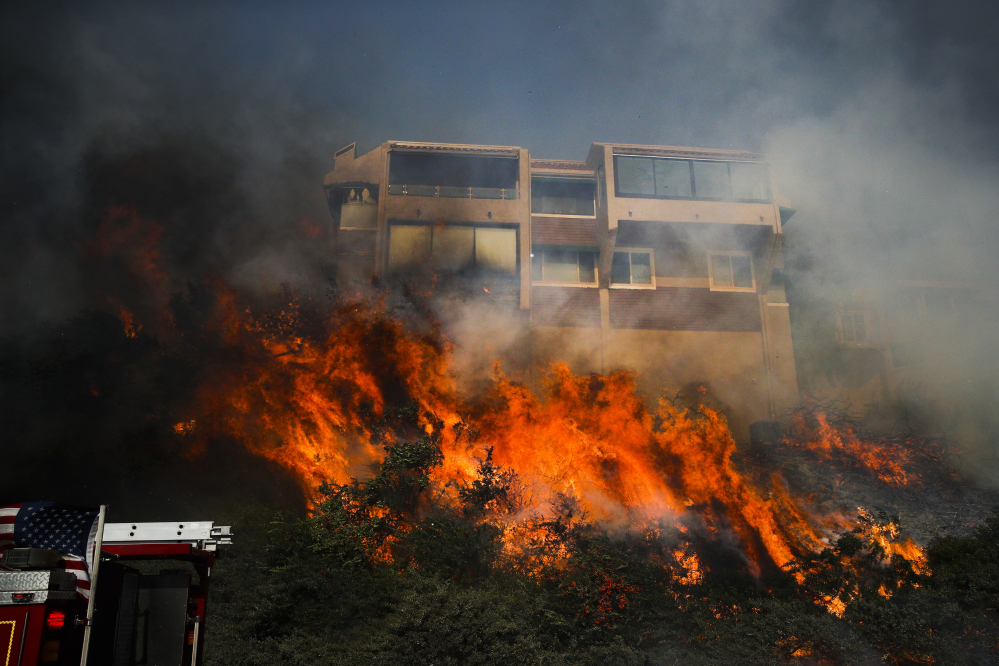 A wildfire threatens a home in Ventura, Calif. Democrats have assailed Republicans for omitting California's wildfire victims from the House bill's tax advantages for disaster victims. "If they call out one kind of devastation over another, that stinks," Californian Larry Keyser said.