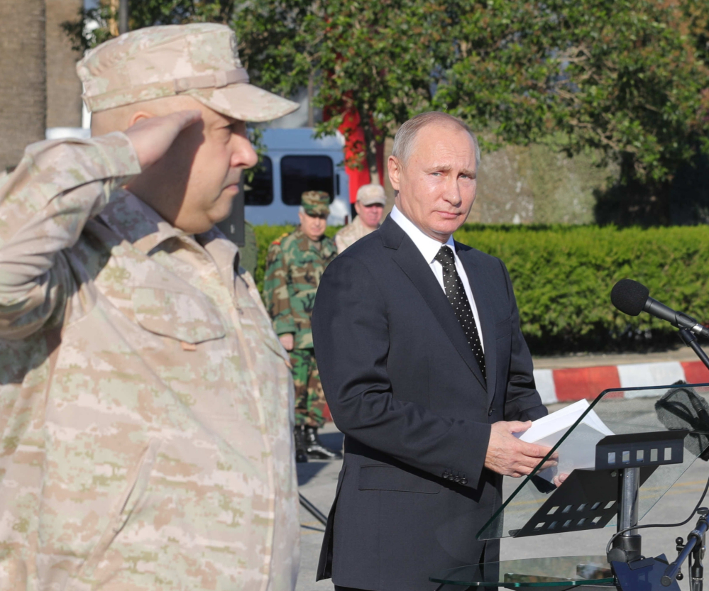 Russian President Vladimir Putin appears in Syria on Monday with Col. Gen. Sergei Surovikin, his commander there.