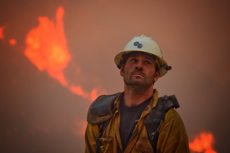 Santa Barbara County Fire Department crew member Nikolas Abele keeps an eye on a hillside for stray embers during an operation in Santa Monica Canyon in Carpinteria, Calif., on Monday. Ash fell like snow and heavy smoke had residents gasping.
