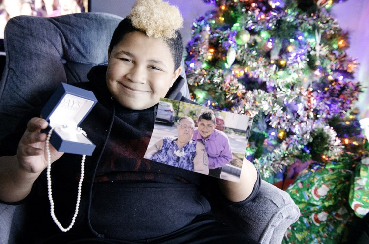 Kaden James, 11, of Turner holds the pearl necklace and earrings that will be a very unexpected Christmas gift for his mother, Michelle James, seen in the photo. "He was so polite ... and so appreciative," says Day's Jewelers Assistant Manager Vanessa Phipps. "It was really kind of what Christmas is all about."