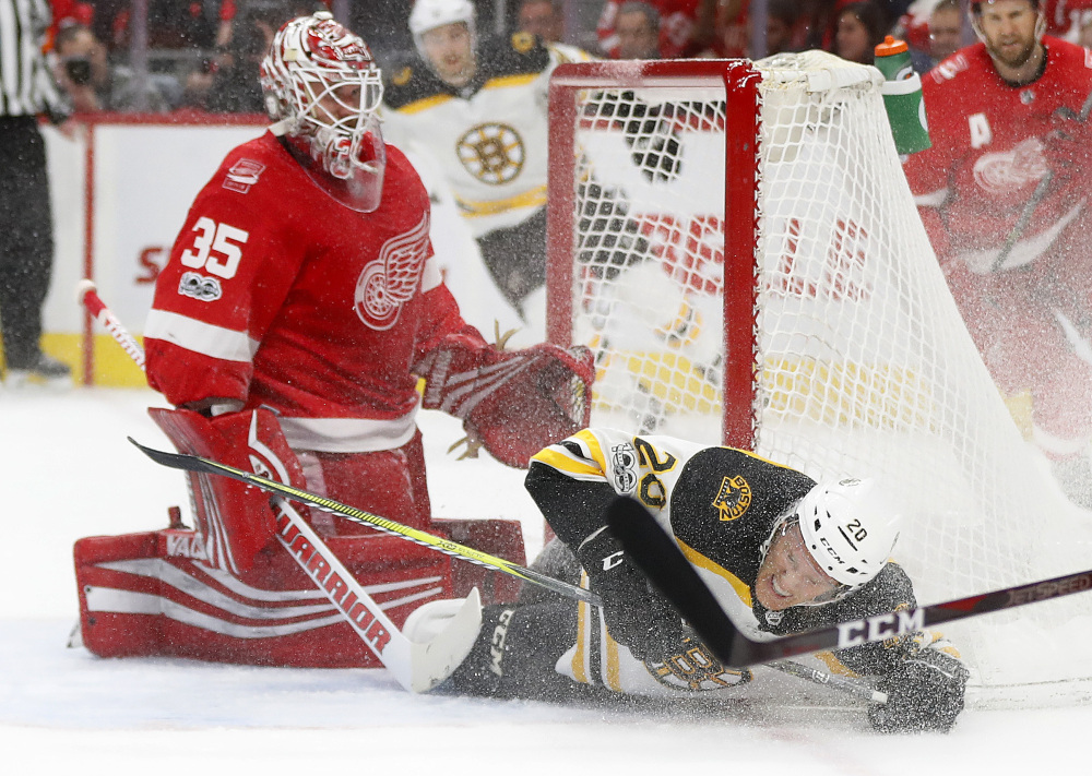Bruins center Riley Nash slides into the net and Red Wings goalie Jimmy Howard in the first period.