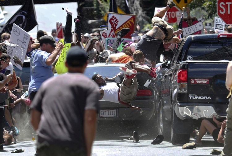 People are thrown into the air as a car drives into a group of protesters demonstrating against a white nationalist rally in Charlottesville, Va., on Aug. 12, 2017. The white nationalists were holding the rally to protest plans by the city of Charlottesville to remove a statue of Confederate Gen. Robert E. Lee. There were several hundred counterprotesters marching in a long line when the car drove into a group of them.