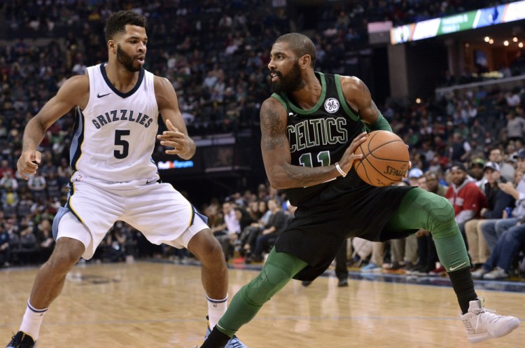 Celtics guard Kyrie Irving controls the ball against Grizzlies guard Andrew Harrison in the second half Saturday night in Memphis, Tenn. Irving scored 20 points and Boston won 102-93.
