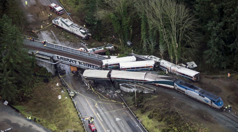Cars from a derailed Amtrak train dangle from an overpass over Interstate 5 or sit alongside the rail bed in DuPont, Wash. The train was on its first-ever run along a faster new route between Seattle and Portland, Oregon, when the derailment occurred Monday morning.