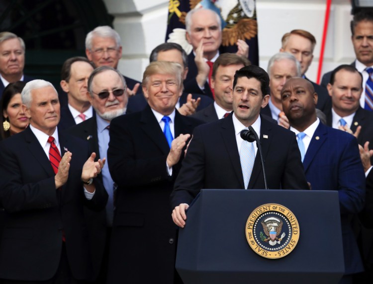 House Speaker Paul Ryan speaks while President Trump and Vice President Mike Pence applaud outside the White House on Wednesday as they celebrate the tax cut plan.