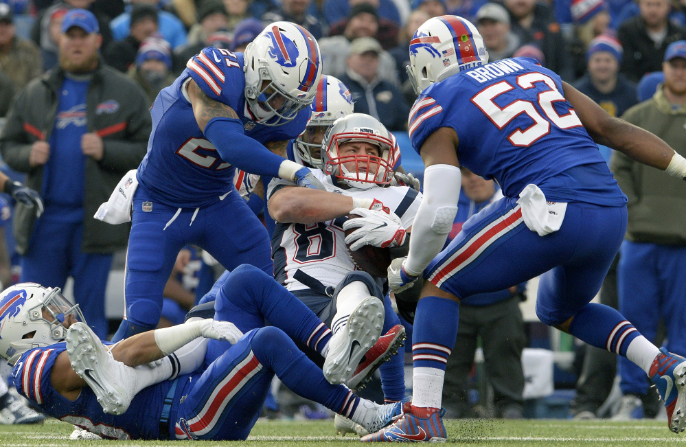 Rob Gronkowski is wrapped up by Tre'Davious White, top left, and other Buffalo defenders during a 23-3 New Eng;and win on Dec. 3. Buffalo might have ideas of revenge from a late hit by Gronkowski, but more important is staying alive in the chase for a playoff berth.