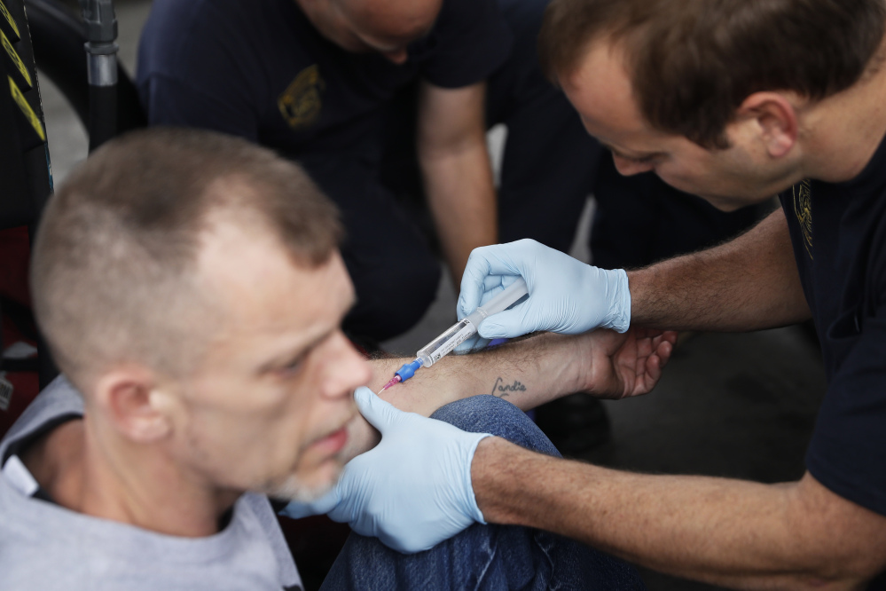 Medics with the Cincinnati Fire Department administer injectable naloxone to a man while responding to a possible overdose report at a gas station in downtown Cincinnati. Ohio was second in the nation in drug overdose deaths last year.