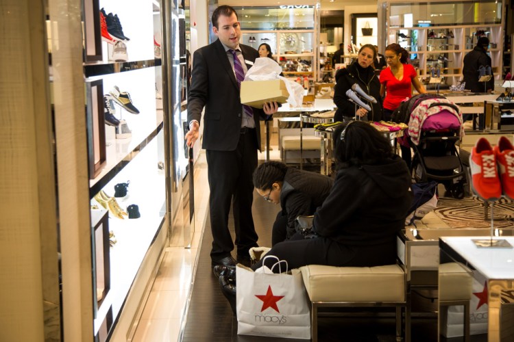 A Macy's employee, at left, helps customers at a department store in New York in 2016. Bloomberg/Michael Nagle