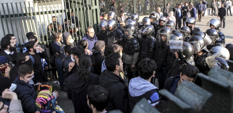 In photo taken by an individual not employed by the Associated Press and obtained outside Iran, anti-riot police prevent university students from joining others protesting Iran's weak economy in Tehran on Saturday. The outpouring of public discontent is the most widespread since 2009.
