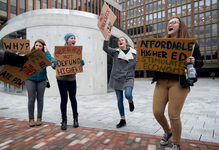 Bowdoin College students, from left, Elise Lindbergh, Maya Morduch-Toubman, Isabella McCann and Haley Maurice lead protesters in a chant in the plaza outside of U.S. Sen. Susan Collins' office in Portland on Friday. 