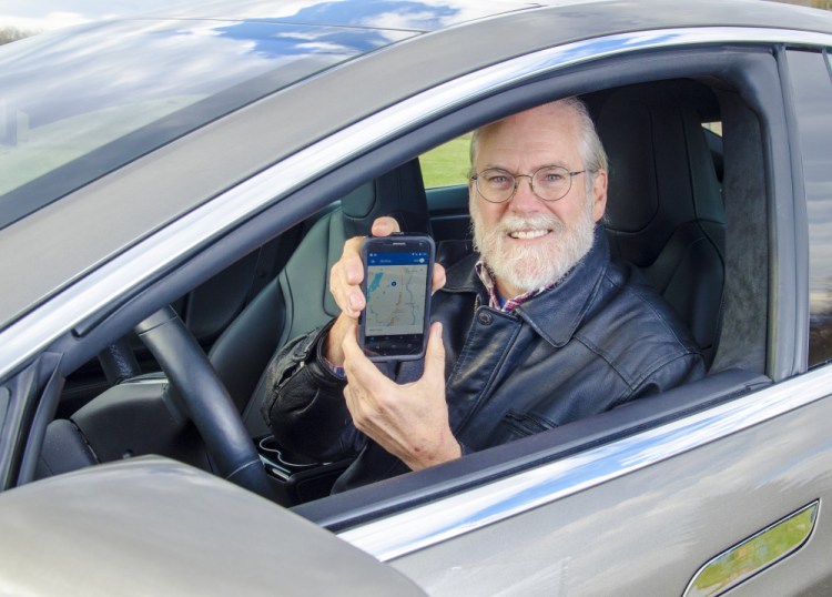 Scott Cowger holds up his phone with the Uber app on it Wednesday in his Tesla in Hallowell.