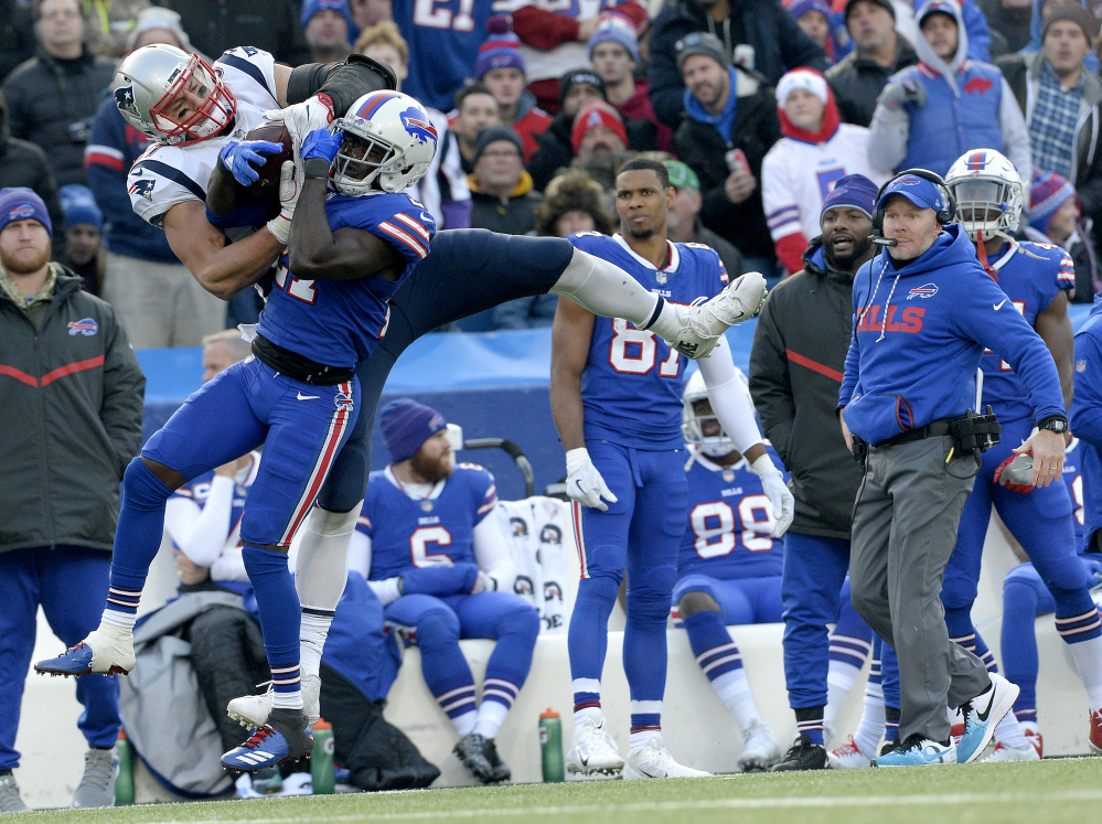 New England Patriots tight end Rob Gronkowski, left, makes a catch as Buffalo Bills cornerback Tre'Davious White (27) defends during the second half Sunday in Orchard Park, New York. Bills head coach Sean McDermott, right, looks on during the play.