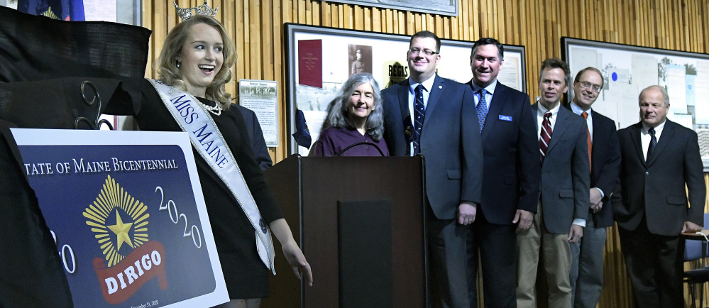 Miss Maine, Katie Elliott, unveils the Maine Bicentennial Commemorative License Plate on Monday in Augusta.