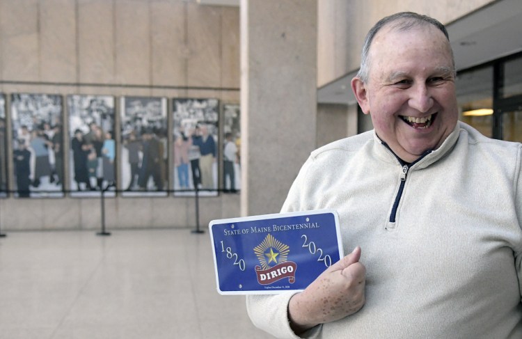 Howard Lowell, of South Thomaston, holds a Maine Bicentennial Commemorative License Plate on Monday after a ceremony in Augusta.