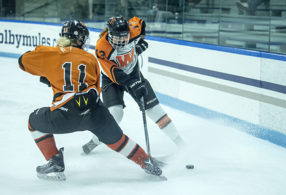 Winslow/Gardiner's Sarah Stevens (13) battles for the puck with Brunswick's Colleen McKearney (11) on Wednesday at Colby College in Waterville.