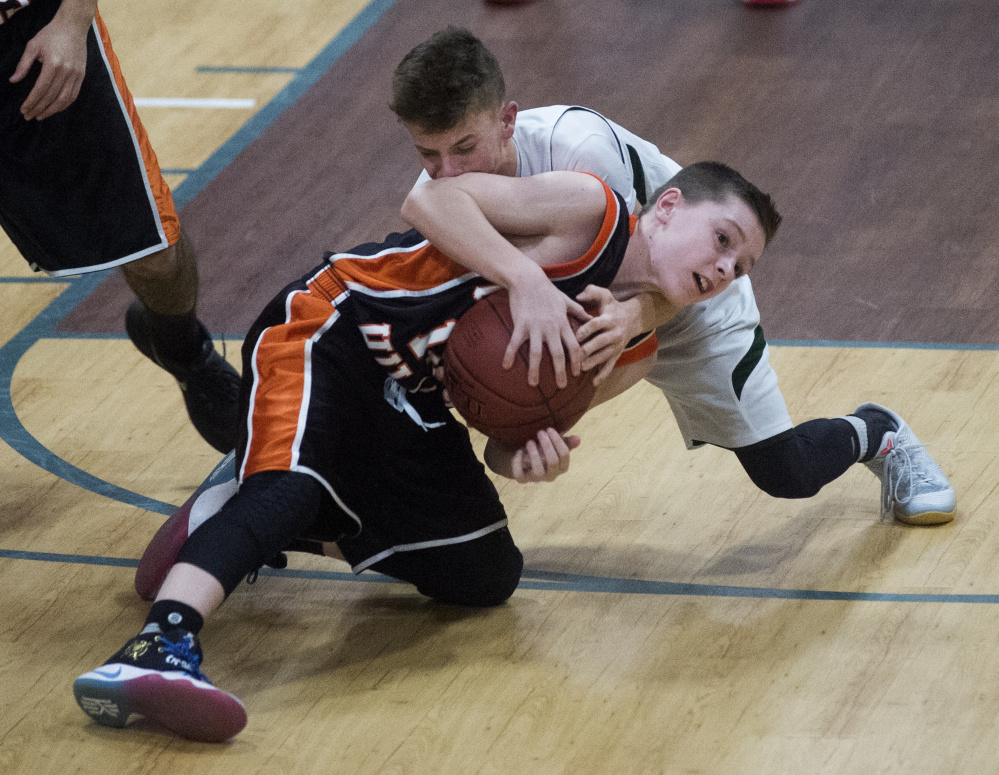 Temple's Micah Riportella, back, battles for the loose ball with Forest Hills' Parker Desjardins during a game last season in Waterville. The Bereans and Tigers lost some key players to graduation, but both return enough talent to stay in the playoff hunt.