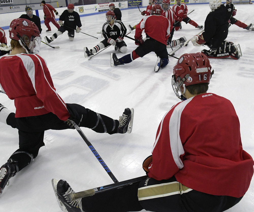 Members of the Cony/Hall-Dale/Monmouth hockey team get loose before a Nov. 28 practice in Hallowell.