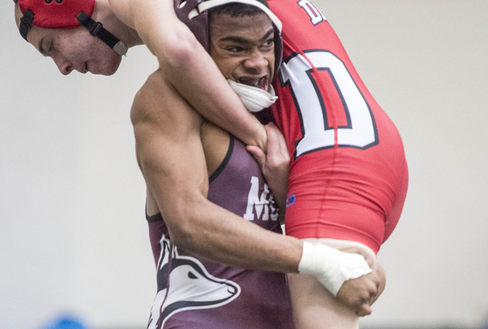 Maine Central Institute senior ZyAnthony Moss, left, gets a hold of Dexter's Isaac Webber in a 132-pound match last Saturday at Mount View High School in Thorndike.