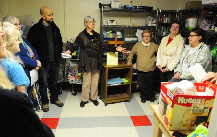 The Rev. Justin Frank, of Penney Memorial Baptist, left, and The Rev. Joan Smith, of South Parish Congregational Church, center, joined other local clergy in the The Everyday Basics Essentials Pantry at the end of a blessing ceremony on Thursday at the former St. Mark's Parish Hall on Pleasant Street in Augusta.