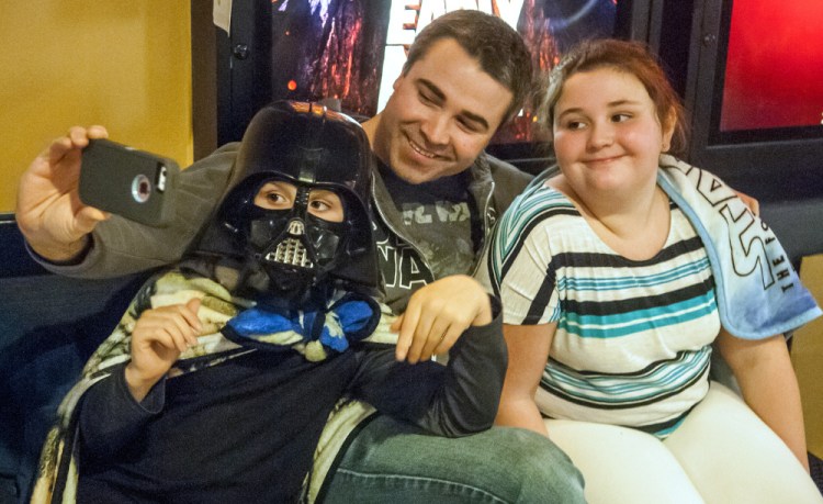 Jake Sturtevant, center, takes a selfie with his children, Simon Sturtevant, 8, left, and Bella Sturtevant, 11, on Thursday before they go into the opening show of "Star Wars: The Last Jedi" at Regal Cinemas in Augusta.