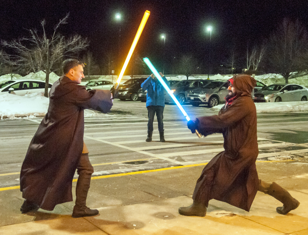 Dressed in Jedi robes, Pete Spiegel, left, and Brian Juengest stage a lightsaber duel on the sidewalk before the opening show of "Star Wars: The Last Jedi" on Thursday at Regal Cinemas in Augusta.