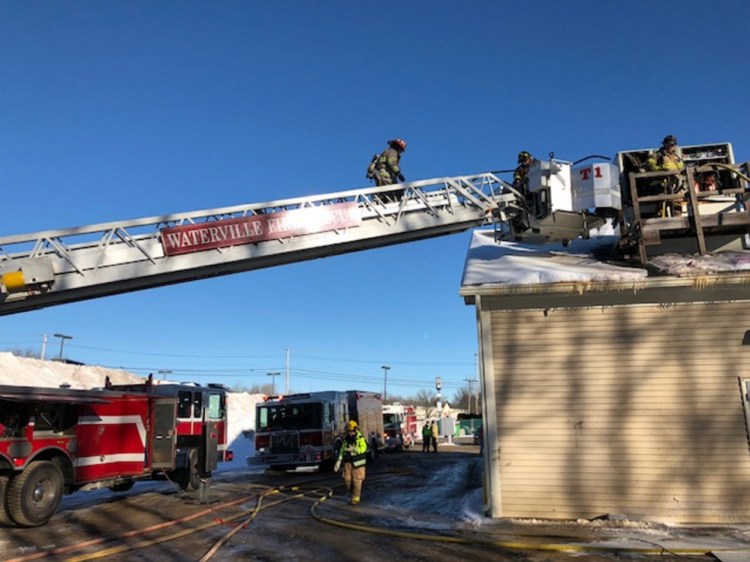 Firefighters work Friday from a Waterville Fire Department ladder truck on the heating and air conditioning unit on the roof of the Dairy Queen in the KMD Plaza mall off Kennedy Memorial Drive in Waterville.