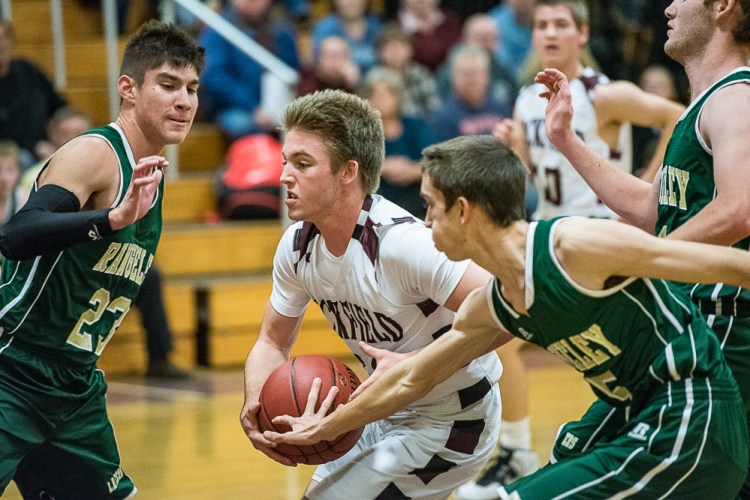 Buckfield's Noah Wiley drives to the basket as Rangeley's Leonardo Perez and Ian Lillis defend during a Class D South game Friday night in Buckfield.