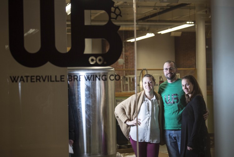 Waterville Brewing Company co-owners Amber Willett, left, Ryan Flaherty, center, and Candice Flaherty, pose for a portrait at their Hathaway Creative Center location on Thursday.
