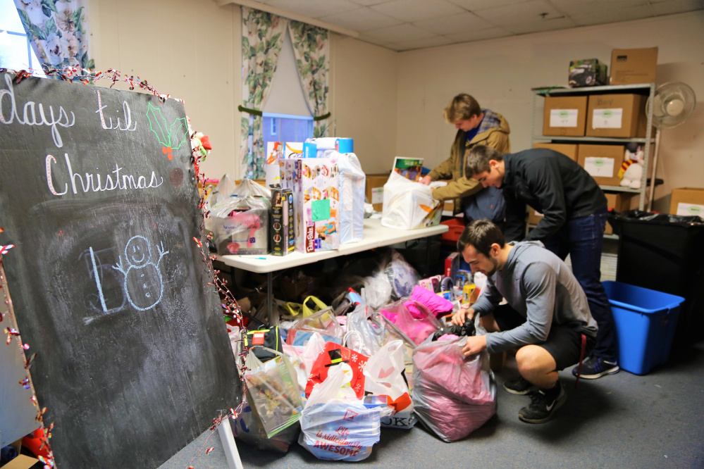 Messalonskee High School students, from front to back, Noah Tuttle, Chase Warren and Colby Charette help deliver a roomful of gifts that were donated to the ShineOnCass Foundation benefit Warming Up for Christmas. In addition to concert goers, the school's student council and athletic teams collected items to help fill the 1,700 boxes distributed to children through the Maine Children's Home for Little Wanderer's Christmas Program.