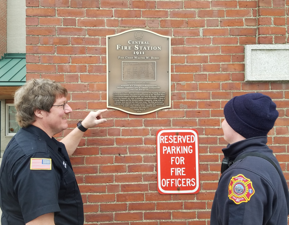 Lt. Scott A. Holst, left, and Firefighter Edward Moult look at the historical plaque commemorating the Old Central Fire Station recently was added to the building.