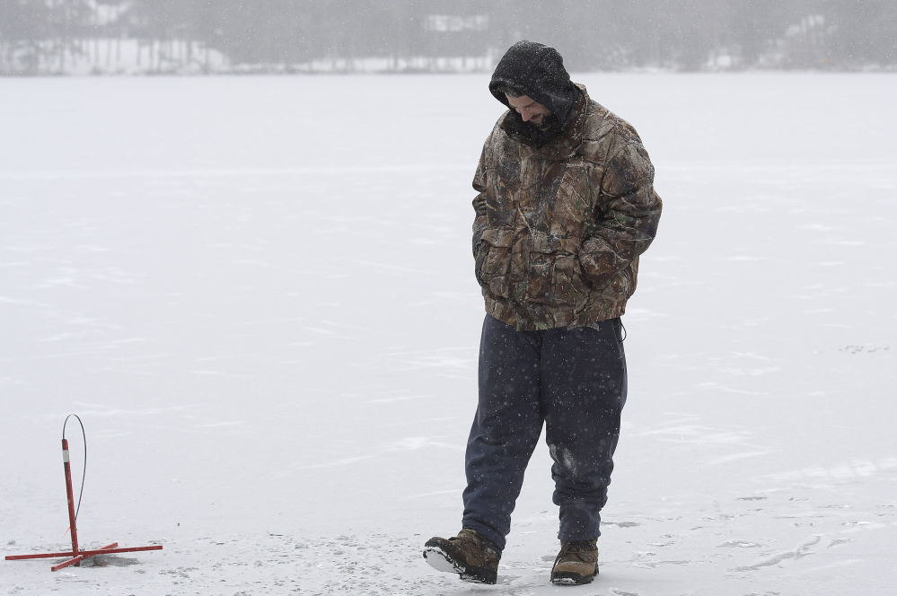 Billy Gayton, of Leeds, waits Monday for a flag while ice fishing on Cochnewagon Lake in Monmouth. Gayton measured 5 inches of ice along the shore, where he placed traps, and 3 inches about 100 yards out. The shelf encouraged him to wait patiently in freezing temperature to catch a fish. "I got to take care of that itch somehow," he said.
