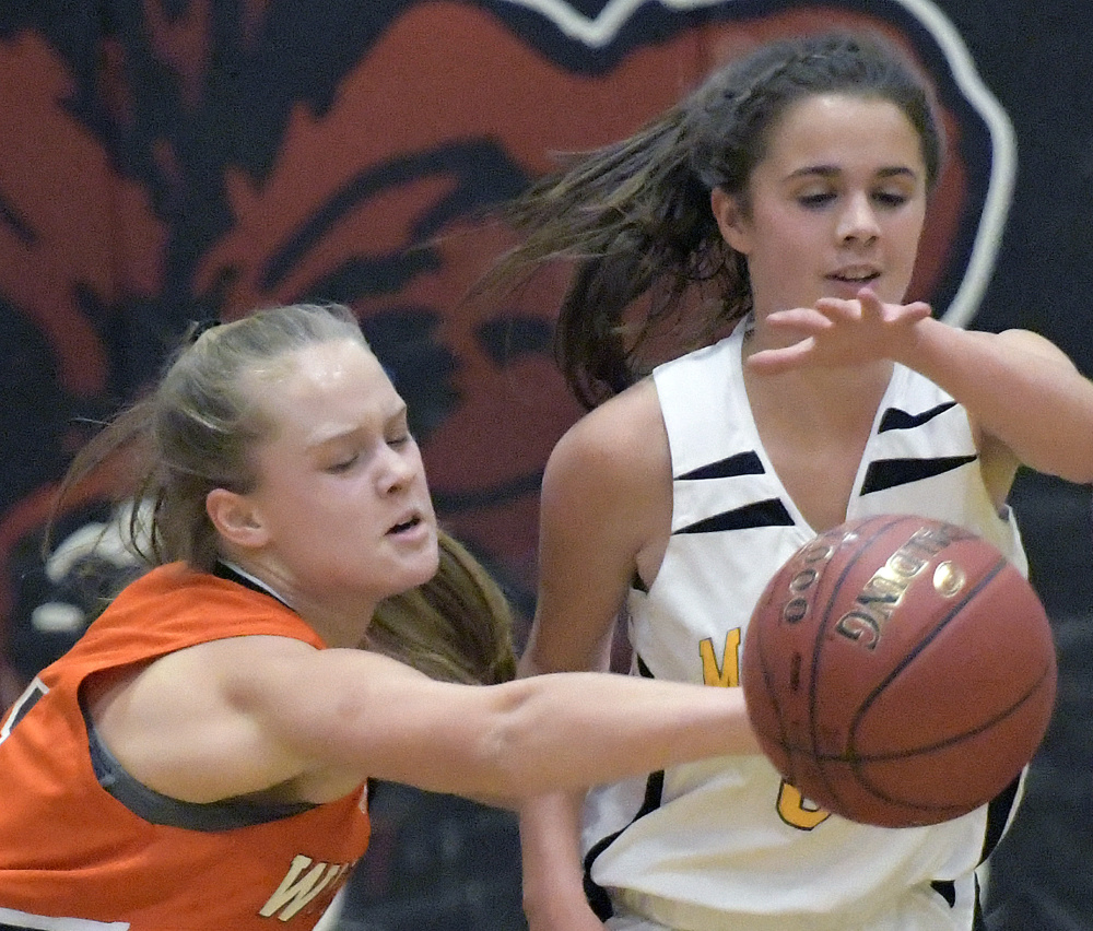 Maranacook's Kaylee Jones, right, gets a ball knocked away by Winslow's Silver Clukey during a Kennebec Valley Athletic Conference Class B game Tuesday in Readfield.