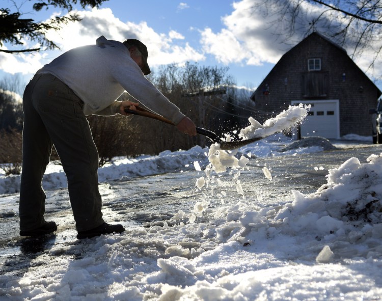 Larry Palleschi scrapes ice on Wednesday from the driveway of his parents' home in Monmouth. Palleschi expects to be back at it again this weekend after a storm forecast to bring several inches of snow and some freezing rain to the region ahead of Christmas Day.