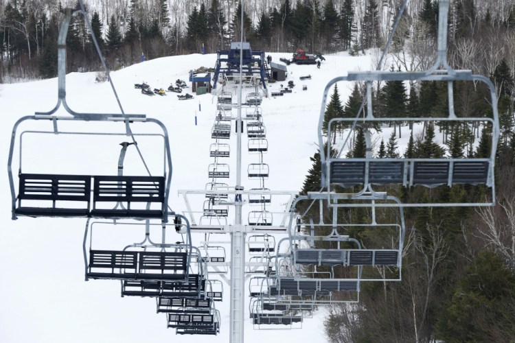 Workers repair the King Pine chairlift at Sugarloaf Mountain Ski Resort in Carrabassett Valley, on March 26, 2015. On Tuesday some skiers were stuck for five to 10 minutes because of a power outage that affected thousands in Franklin County.