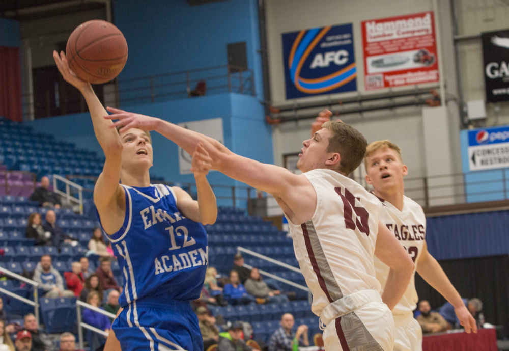 Erskine Academy's Austin Dunn (12) takes a shot while George Stevens Academy's Taylor Schildroth (15) defends at the Maine Gold Rush Invitational Tournament on Tuesday at the Augusta Civic Center.