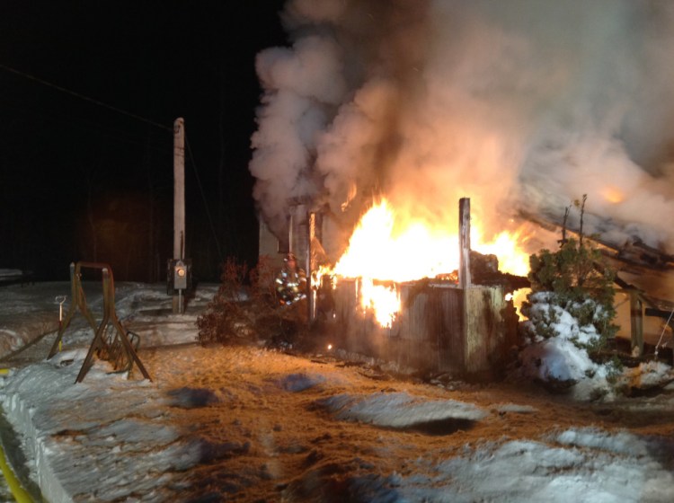 Flames race through a home late Tuesday night at 58 Outlet Road in Augusta. Two people escaped without injury.