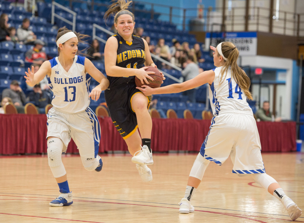 Medomak's Hallie Kunesh, center, feels the pressure from Madison's Emily Edgerly (13) and Sydney LeBlanc (14) at the Gold Rush Invitational Tournament on Wednesday at the Augusta Civic Center.