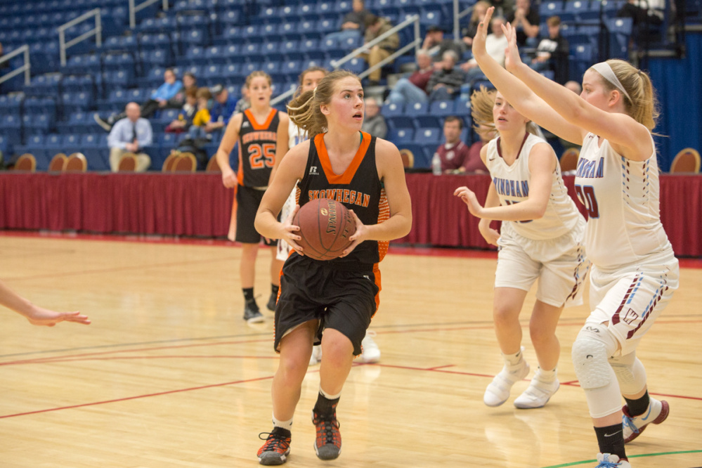 Skowhegan's Annie Cooke, left, goes in for a shot while Windham's Tara Flanders, right, defends at the Gold Rush Tournament on Wednesday at the Augusta Civic Center.