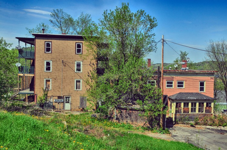 Dilapidated buildings at 11 State St., left, and 15 Morton Place, both in Augusta, are seen in May 2017 before the city demolished them. Officials now hope to sell the properties and return them to the tax rolls.