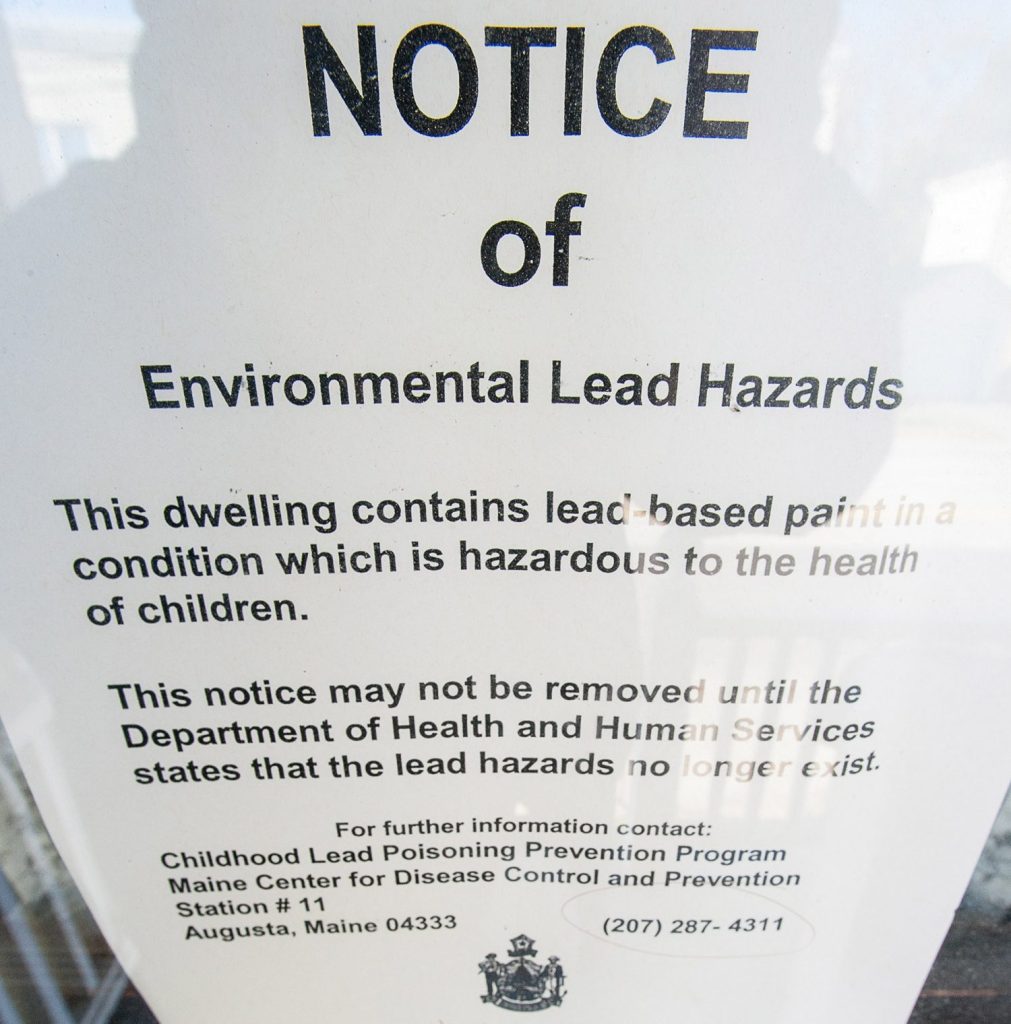 A lead paint notice on the storm door on the side porch entrance at 144 Walnut Street in Lewiston.