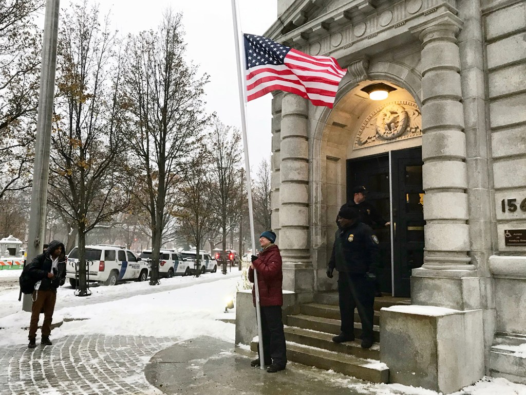Rob Levin of Portland, who is a Quaker and an attorney, stands with a flag at half-staff in front of the federal courthouse in Portland on Tuesday to signify his disapproval of the Trump administration’s plan to withdraw the U.S. from the Paris climate agreement. Levin was detained briefly after refusing to leave but was released without charges.