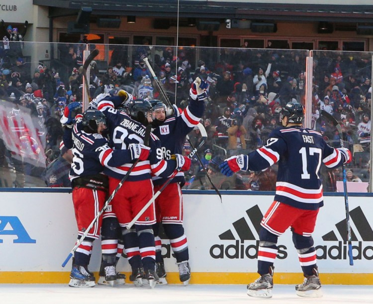 New York Rangers players celebrate Monday afternoon after an overtime goal by J.T. Miller ended the NHL Winter Classic, giving the Rangers a 3-2 win over the Buffalo Sabres.